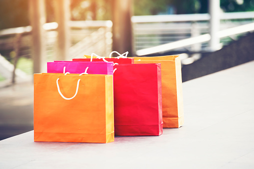 Shopping bags of women crazy shopaholic person at shopping mall. Woman love online shopping website with sales tags. E-commerce Bag Concept.