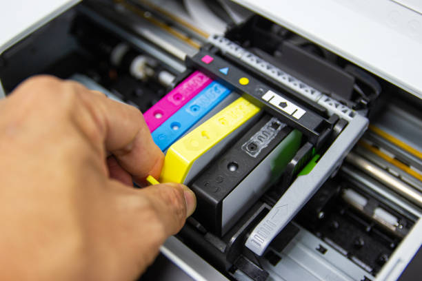 istock Technicians are installing the color printer inkjet cartridge of the printer 1163649338