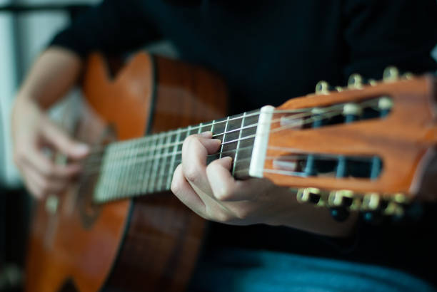 istock woman's hands playing acoustic guitar, close up 1163653986