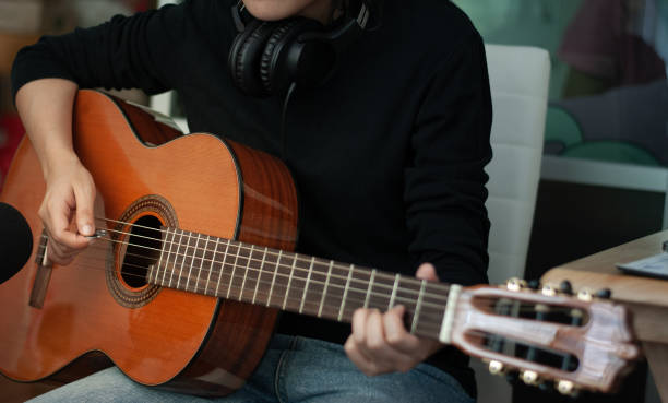 istock woman's hands playing acoustic guitar, close up 1163654009