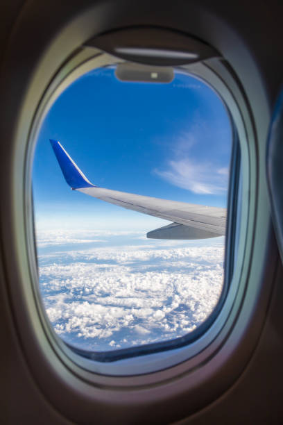 istock Looking out the window of airplane, Sky with white clouds viewed from inside an airplane windows. 1163654327