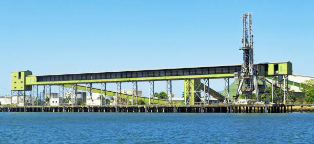 Sugar terminal dock with molasses storage tanks in background. Export Sugar shipping terminal with molasses storage tanks in background. Port Bundaberg commercial ship loading facility/dock in the Burnet River, Queensland, Australia. downunder stock pictures, royalty-free photos & images