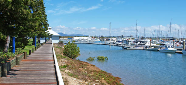 istock Tropical timber waterfront marina board walk with boats. 1163657011