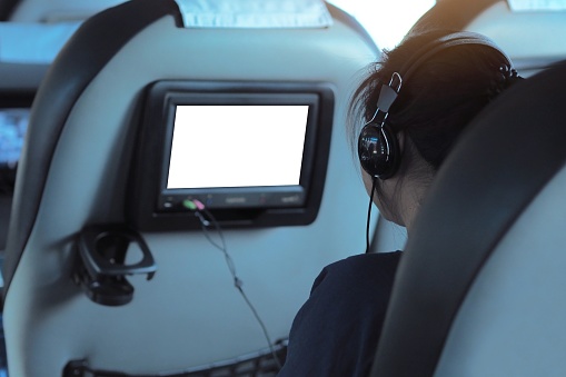 Passengers are using infotainment system in the tour bus to listen to music - Blank and white Display