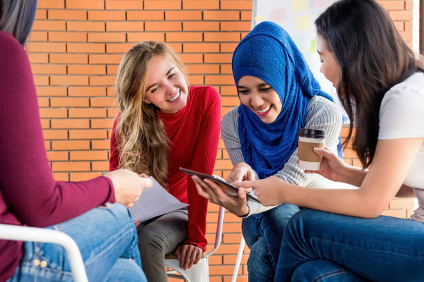 istock Diverse women looking at tablet pc together in group meeting 1163660558