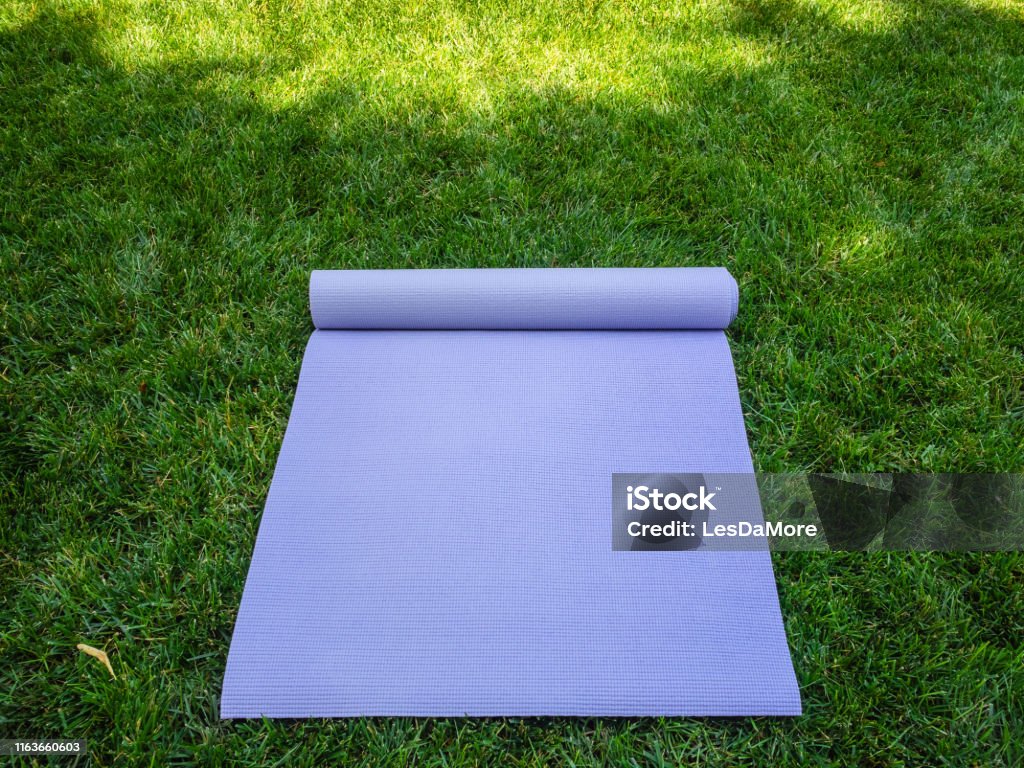 microscopisch Geruststellen Goed doen Unfolded Purple Yoga Mat Or Fitness Mat Yoga Mat Or Pilates In The Shade On  The Green Grass Stock Photo - Download Image Now - iStock