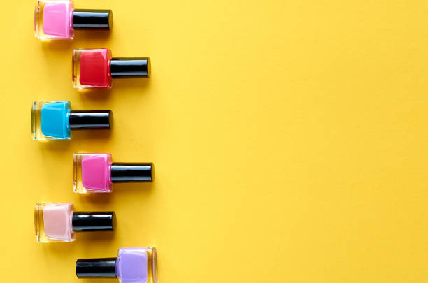 istock Color nail polish bottles on yellow background composition. 1163664509