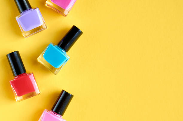 istock Color nail polish bottles on yellow background composition. 1163664514