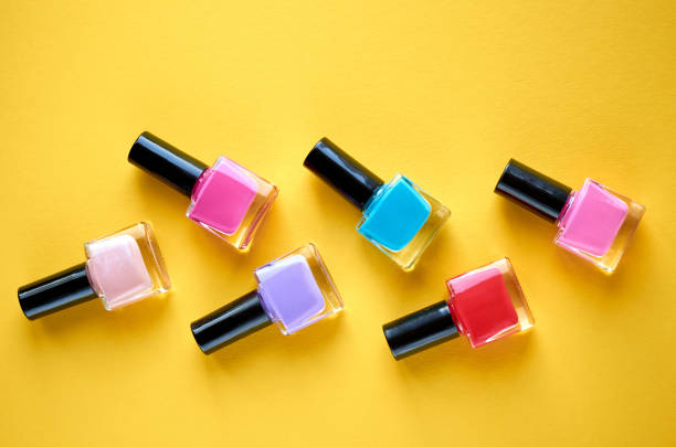 istock Color nail polish bottles on yellow background composition. 1163664522