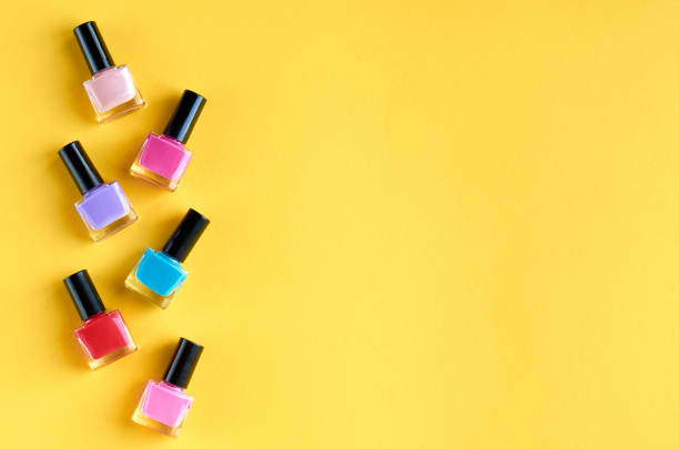 istock Color nail polish bottles on yellow background composition. 1163664525