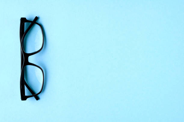 istock Black glasses on blue background composition, eyeglasses. 1163665294