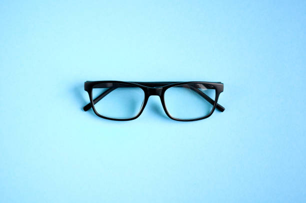 istock Black glasses on blue background composition, eyeglasses. 1163665296
