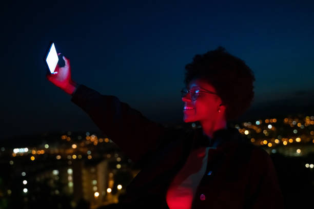 istock Woman taking a selfie with city lights at background 1163667603