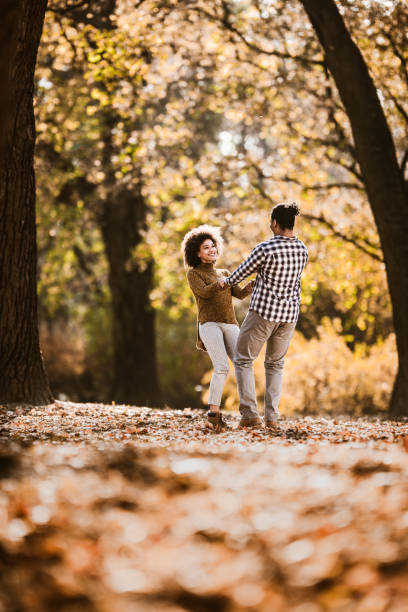 istock Carefree black couple having fun while spinning in autumn day. 1163667609