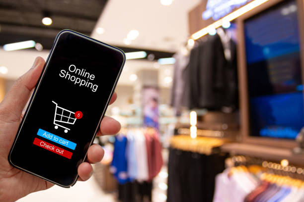 istock Person using smartphone buying and making a payment digitally via application on blur shopping mall background - internet online home shopping concept 1163670066