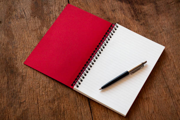 木製のテーブルテクスチャの背景に赤いノートブックとペン、学習のための概念、テキストメッセージを追加するためのコピースペースを備えています。 - note pad paper spiral diary ストックフォトと画像