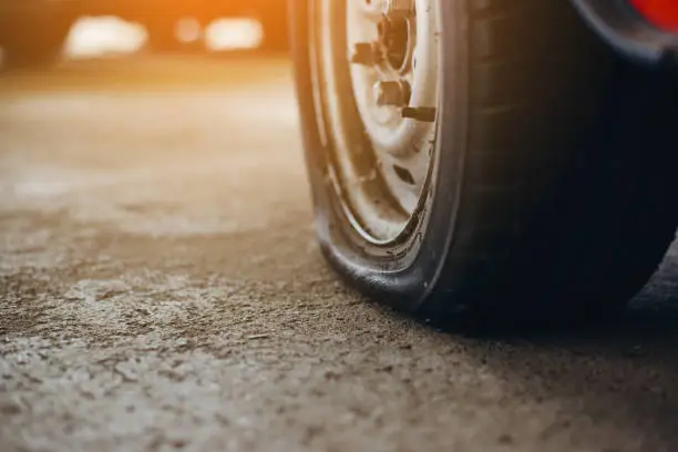 Photo of Selective focus flat tire of old car park on the street waiting for repair,copy space, (vintage tone)