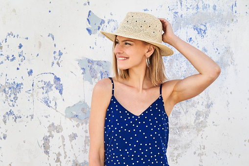 Smiling young woman in straw hat, looking away