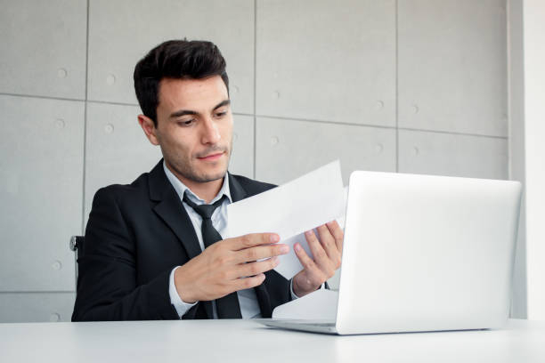 istock Male employees are holding documents in skepticism. 1163674628