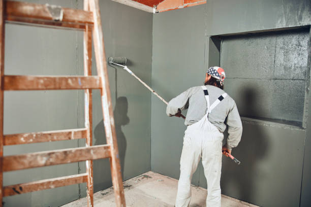 istock Painter painting walls with a extender roller indoors. 1163674812