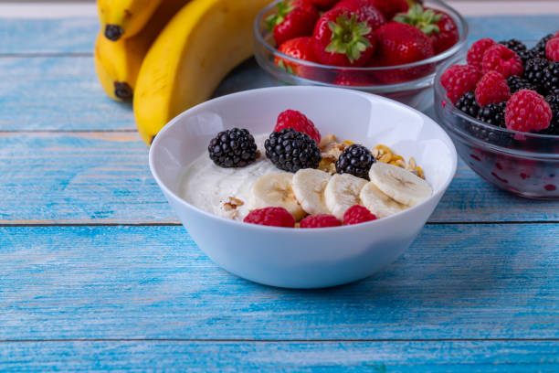 istock Muesli with yogurt and fruit on wooden table. 1163676079