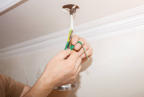 istock Man is holding adhesive tape in his hands. Electrical insulator for light bulb. Maintenance repair works in the flat. Restoration indoors. 1163676542
