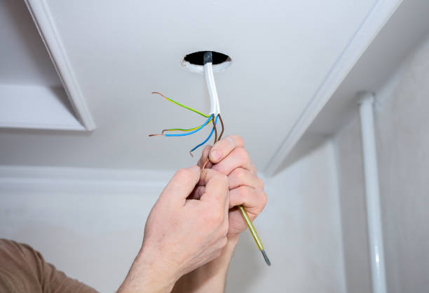istock Man is making electrical insulator. Light bulb wires with adhesive tape. Maintenance repair works in the flat. Restoration indoors. 1163676700