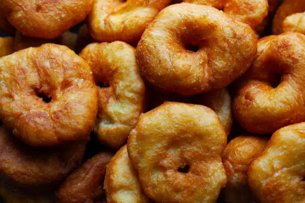 Photo of golden sweet donuts fried in sunflower oil,harmful street food fast cooking
