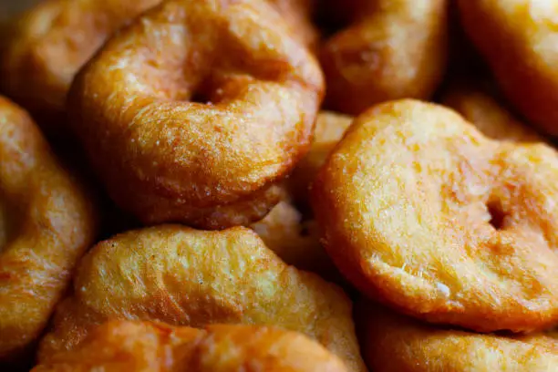 Photo of golden sweet donuts fried in sunflower oil,harmful street food fast cooking