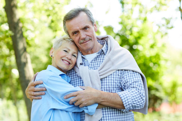 istock Happy Senior Couple Embracing in Park 1163677899