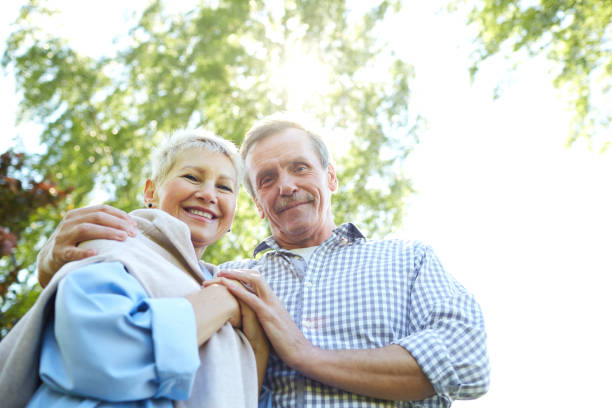 istock Happy Senior Couple Walking in Park 1163677906