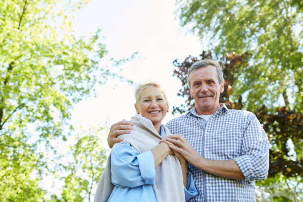 istock Smiling Senior Couple Walking in Park 1163677909
