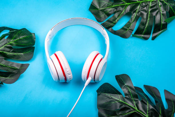 istock White red music headphones on technology background Notbook computer on a blue background. Happy holidays. 1163678035
