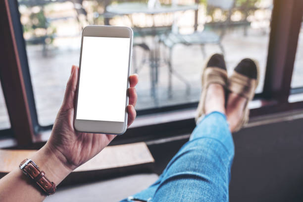 istock a woman holding white mobile phone with blank desktop screen 1163681262