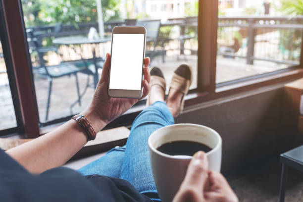 istock a woman holding white mobile phone with blank desktop screen 1163681445