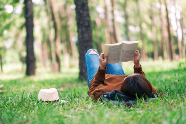 istock A woman lying and reading a book in the park 1163681456
