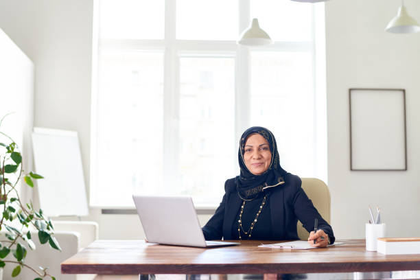 istock Confident modern businesswoman at table in office 1163681994