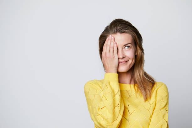 Smiling woman covering eye