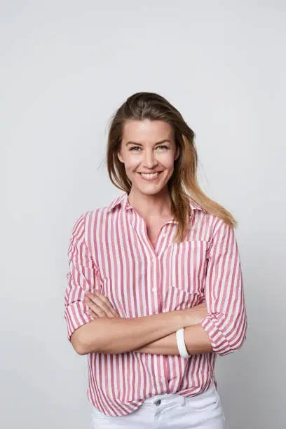 Woman smiling striped shirt with arms folded, portrait