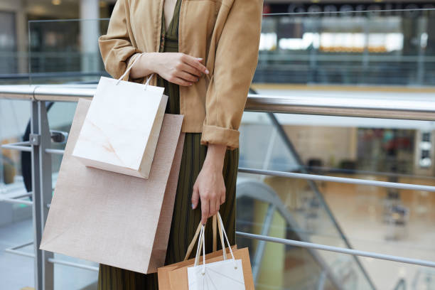 istock Lady in jacket holding shopping bags 1163683432
