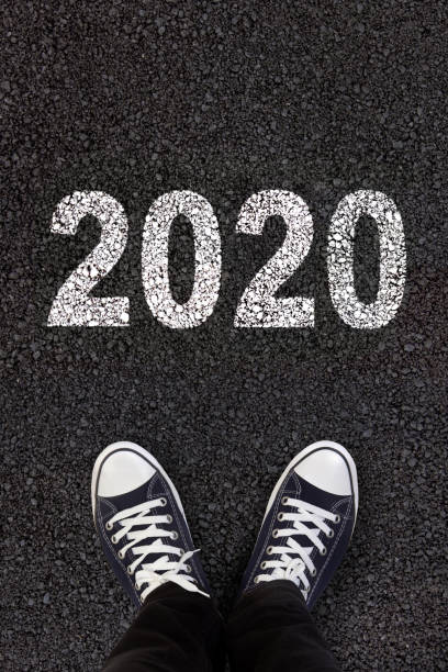 istock 2020 written on fresh asphalt with man's feet 1163686333