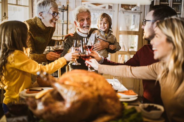 istock Happy multi-generation family toasting while having Thanksgiving lunch in dining room. 1163693924