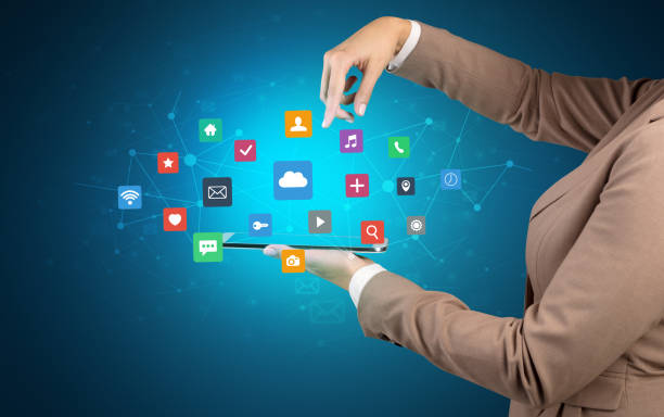 istock Hand holding tablet and application icons above 1163695621