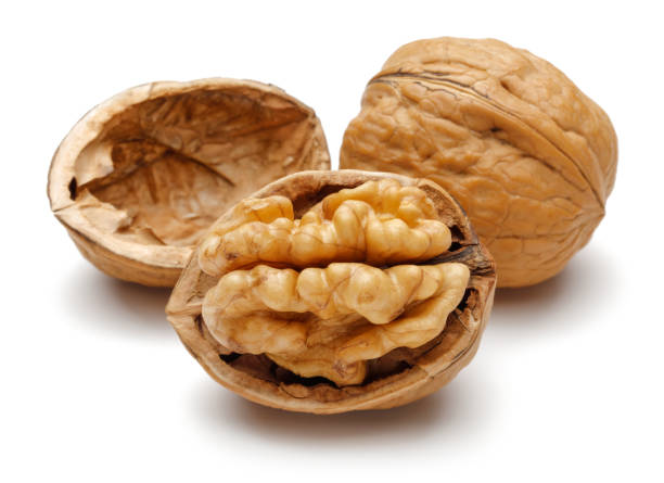 istock Whole and cracked walnuts isolated on white 1163695905