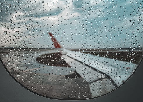 Rain drop at Airplane window before take off when monsoon season.