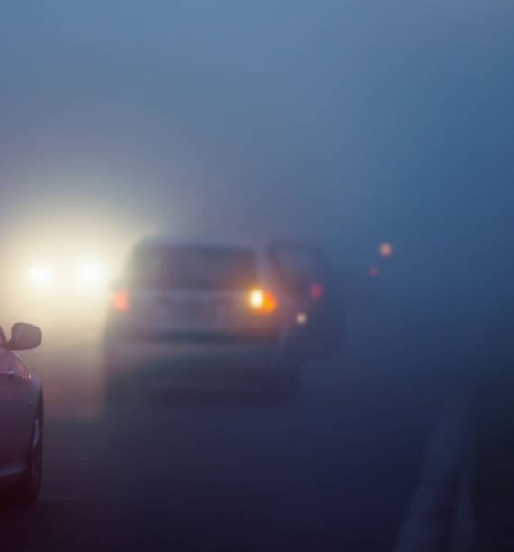 istock Cars driving with headlamps on in thick mist 1163697286