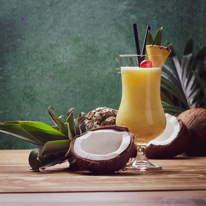 Tropical caribbean cocktail Pina Colada in a glasses on wooden  table with coconut and pineapple.