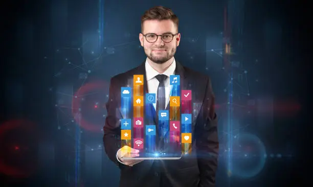 Photo of Man holding tablet with hologram app icons above