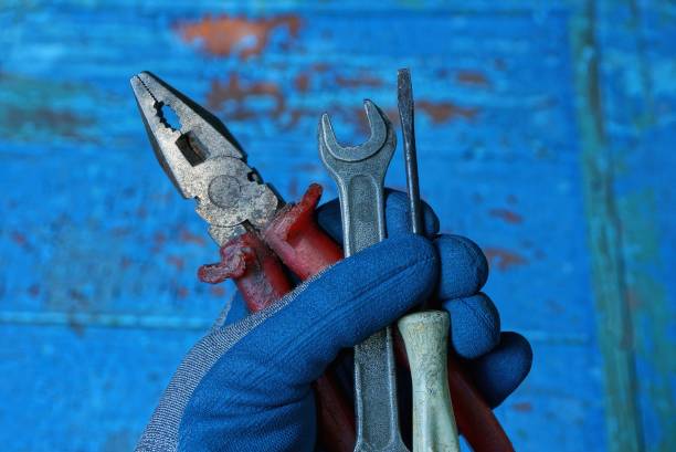 istock hand in a working glove holding a set of tools 1163701102
