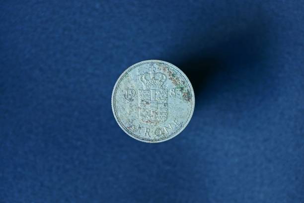 istock old white denmark coin on blue background 1163701133